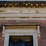 Le finestre del secondo piano culminano con degli eleganti architravi con decori a spirale ai bordi...